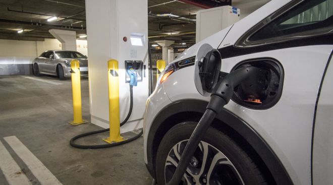 An autonomous test vehicle parked at a fast charging station